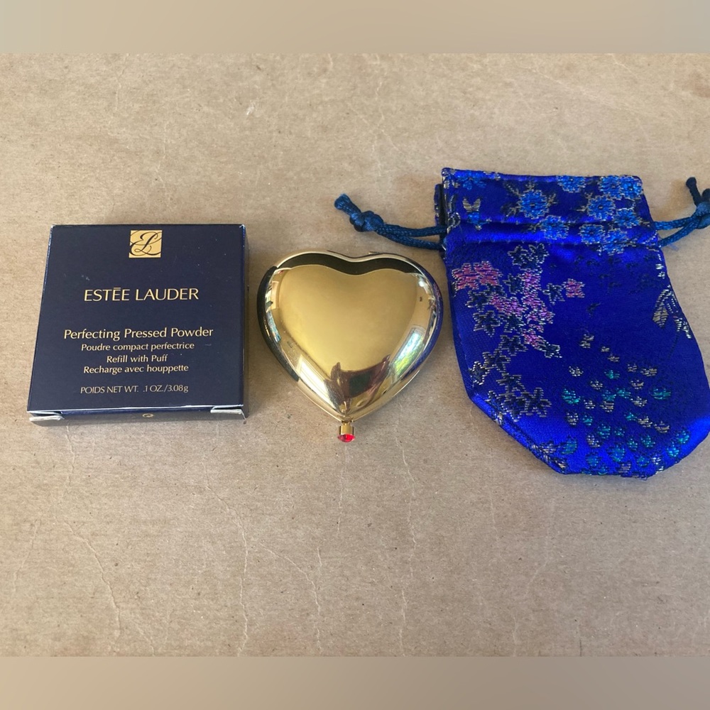 Brand new Estée Lauder heart shape with red gem metal powder compact w/refill.